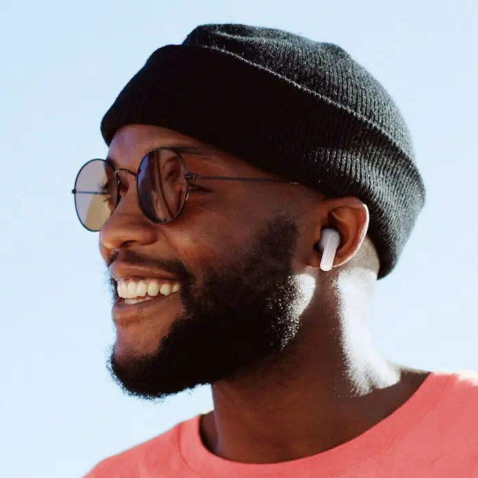 Hama In Ear Kopfhörer Freedom Light II - Weiß - Ein Mann mit Kopfhörern und Sonnenbrille lächelt. Die kabellosen Ohrhörer sind gut sichtbar.