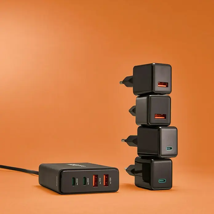 Hama Ladestation 00201979 2 x USB-C, 2 x USB-A - Schwarz - Mehrfach-USB-Ladegerät und 4 USB-Wandstecker in Schwarz auf orangefarbenem Hintergrund, ideal für schnelles und effizientes Laden mehrerer Geräte.