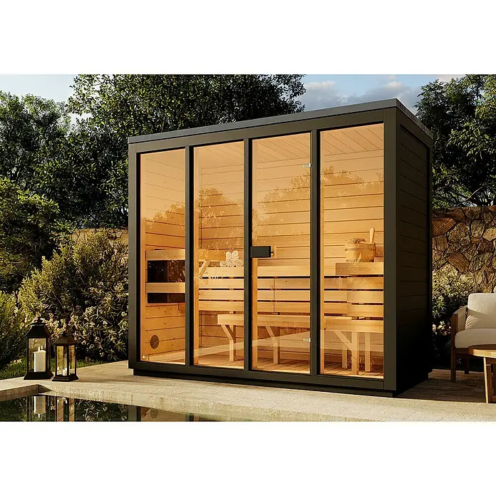 FinnTherm Saunahaus Kuuma L black - Elektroofen, L x B x H: 111 x 242 x 213 cm - Diese Aufnahme zeigt eine moderne Außensauna mit viel Glas und Holzbänken im Inneren, umgeben von üppigem Grün.