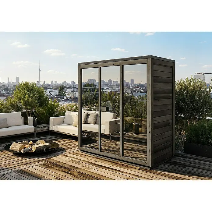 FinnTherm Saunahaus Kuuma M black Spiegelglas 42mm Wandstärke - Elektroofen - Aufnahme einer Outdoor-Sauna mit Holzverkleidung und Glasfront auf einer Dachterrasse mit Stadtblick.
