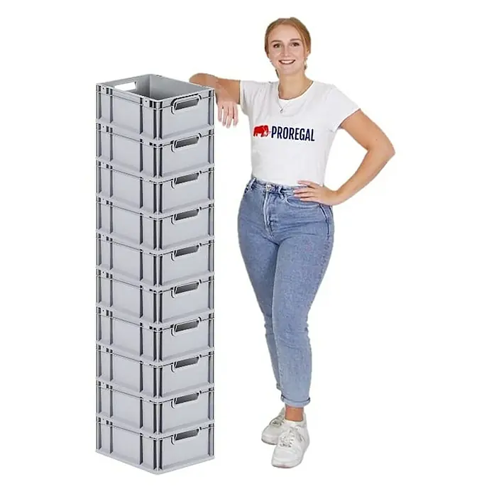 Proregal Eurobox Eurobox NextGen Grip - Kunststoff, Grau - Eine Frau lehnt an einem Stapel grauer Lagerkisten aus Kunststoff mit praktischen Griffen, ideal für Ordnung und Transport.