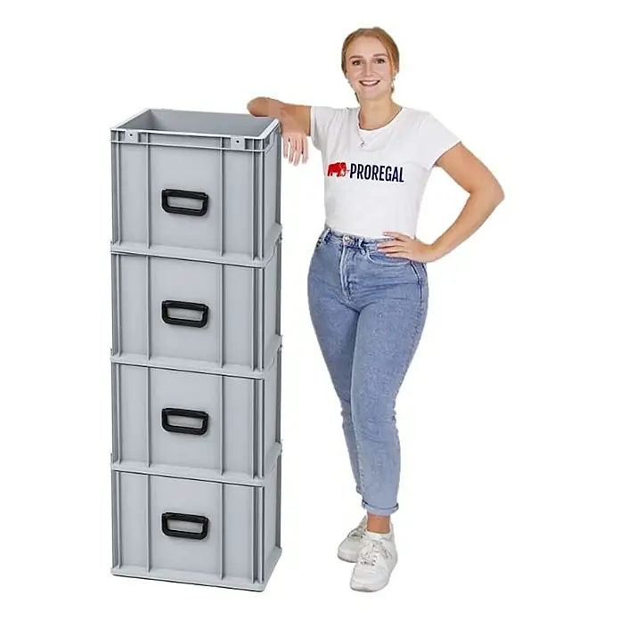 Proregal Euroboxen-Set 4x Eurobox NextGen Portable Uno - Kunststoff, Grau, 4 Stk. - Eine Frau posiert neben einem Stapel grauer Euroboxen mit schwarzen Griffen, die eine praktische und robuste Aufbewahrungslösung darstellen.