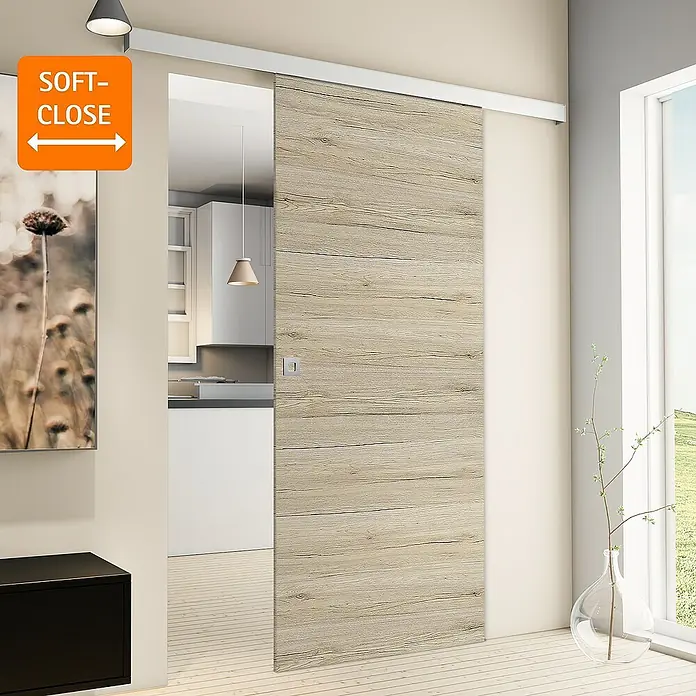 Inova Schiebetür-Komplettset Holz Komplettset Eiche San Remo mit Quadratgriff + Softclose - 880 x 2.035 mm - Eine moderne Schiebetür mit Soft-Close-Funktion, die sich perfekt in ein modernes Interieur einfügt. Die Tür ist aus hellem Holz gefertigt.