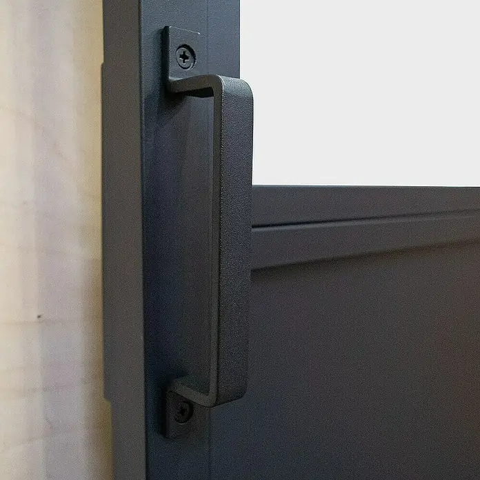 Inova Schiebetür-Komplettset Lofttür Komplettset Stahl Doppelflügelig - 1.800 x 2.150 mm - Nahaufnahme eines mattschwarzen Türgriffs, der mit Schrauben an einer Metalltür befestigt ist. Ideal für moderne Inneneinrichtungen.