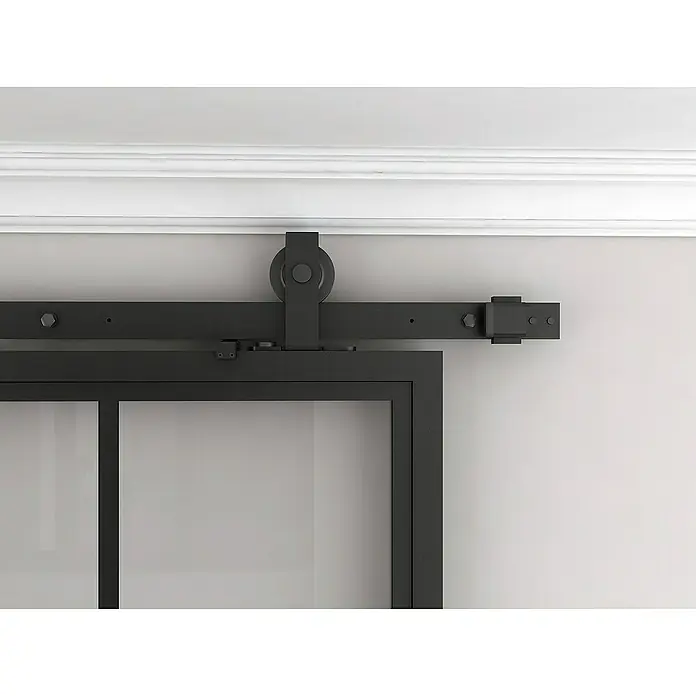 Inova Schiebetür-Komplettset Lofttür Komplettset Stahl Doppelflügelig - 1.800 x 2.150 mm - Detailaufnahme einer schwarzen Schiebetür mit Beschlägen. Die Tür hängt an einer Schiene, die an der Wand befestigt ist.