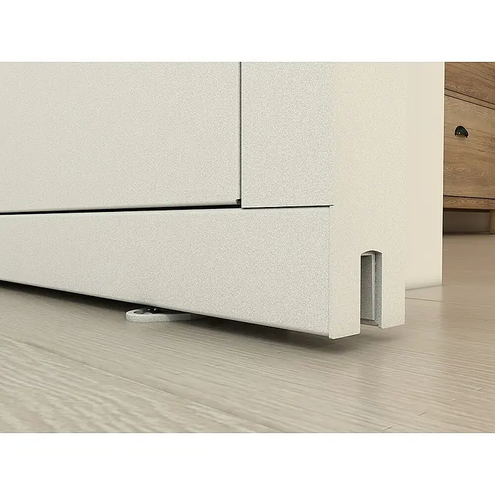 Inova Schiebetür-Komplettset Stahl Loft Klarglas Komplettset 6 Felder Kickplatte weiß inkl. Softclose -  - Detailaufnahme eines hellen Schrankes, der auf einem hellen Holzboden steht, mit Fokus auf die feinen Texturdetails und die minimalistische Gestaltung.