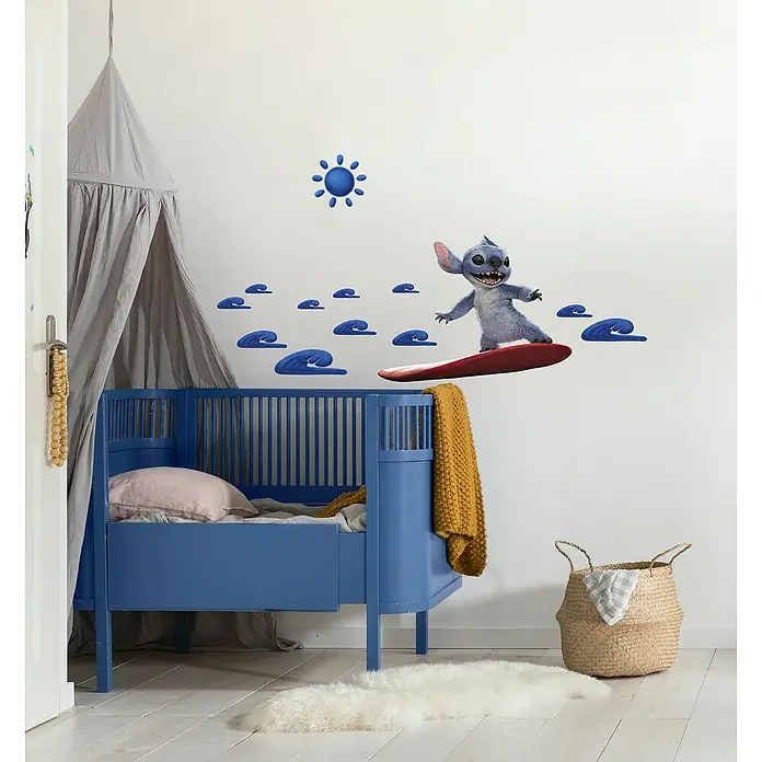 Komar Wandtattoo Disney Stitch Live Action Hit the Waves - Blau/Rot, 70 cm x 50 mm, 13 -tlg. - Kinderzimmer mit blauem Gitterbett, grauem Baldachin und Wandaufkleber von Stitch auf einem Surfbrett, der eine freundliche und spielerische Atmosphäre schafft.