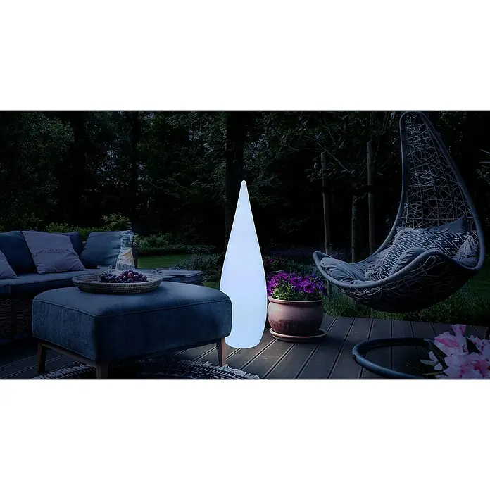 Globo Außenleuchte Vascon - Netzbetrieben, 10 W, Weiß, Mit Leuchtmittel, RGB, Ø x H: 36 x 120 cm - Stimmungsvolle Gartenszene mit beleuchteter Säulenlampe, Lounge-Möbeln und Hängesessel, die eine entspannte Atmosphäre für den Außenbereich schafft.