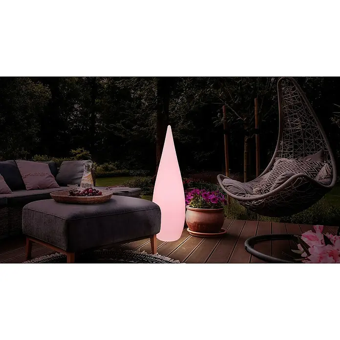 Globo Außenstehleuchte Vascon - Netzbetrieben, 10 W, Weiß, Mit Leuchtmittel, RGB, Ø x H: 36 x 120 cm - Stimmungsvolle Gartenszene mit einem leuchtenden, kegelförmigen Outdoor-Lampe, die ein warmes, einladendes Licht verbreitet, neben einer Sitzecke.