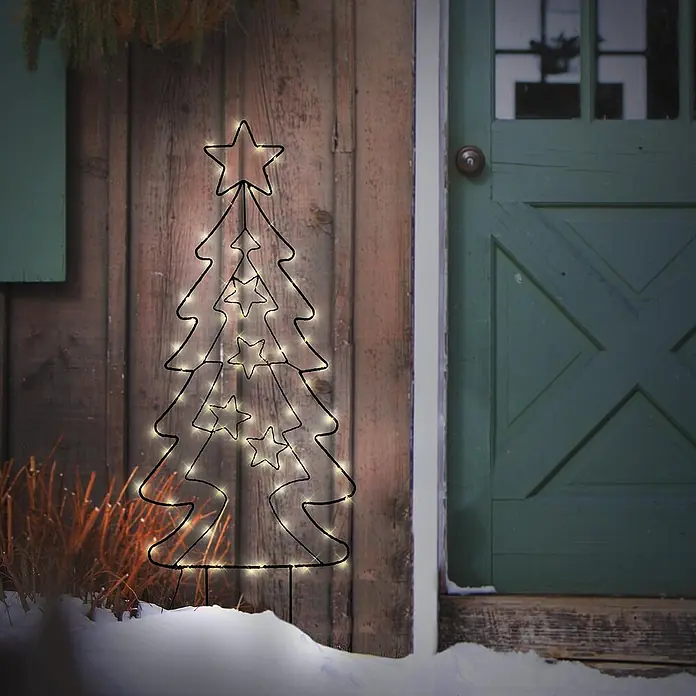 ECD Germany LED-Weihnachtsdekofigur Lichterbaum LED Beleuchtung Gartenleuchte Kunstbaum - 37 x 1 x 87 cm, Schwarz, Akkubetrieben, LED - Festliche Szene mit einem leuchtenden Draht-Weihnachtsbaum mit Sternen, der eine warme, einladende Atmosphäre vor einer rustikalen Holztür schafft.