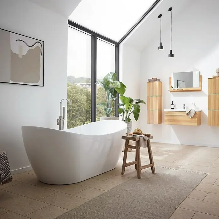 Home Deluxe Freistehende Badewanne OVALO PLUS - Weiß - Elegantes Badezimmer mit freistehender Badewanne, hellem Holzmobiliar und minimalistischer Dekoration, ideal für ein entspannendes Ambiente.