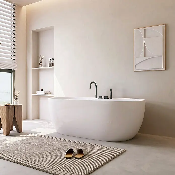 Home Deluxe Freistehende Badewanne LENI inkl. schwarzer Armatur - Weiß Schwarz - Ein modernes Badezimmer mit einer freistehenden Badewanne, einem Teppich mit Pantoffeln und minimalistischer Dekoration.