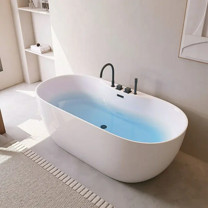 Home Deluxe Freistehende Badewanne LENI inkl. schwarzer Armatur - Weiß Schwarz - Freistehende Badewanne in einem hellen Badezimmer, gefüllt mit blauem Wasser. Die Badewanne hat schwarze Armaturen und ein minimalistisches Design.