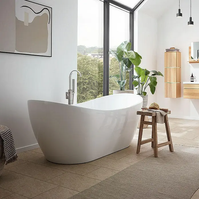 Home Deluxe Freistehende Badewanne OVALO - Weiß - Freistehende Badewanne in einem hellen Badezimmer mit Pflanzen und einem Holzhocker, der eine entspannende Atmosphäre schafft.