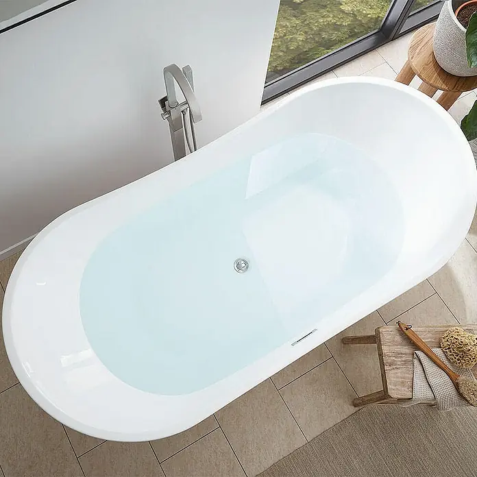 Home Deluxe Freistehende Badewanne OVALO - Weiß - Ein vollgefüllter, freistehender Badewanne mit Armatur, Hocker und einer Pflanze im hellen Badezimmer lädt zum Entspannen ein.