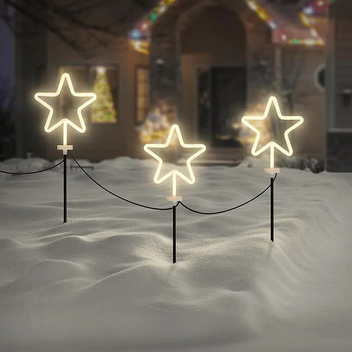 ECD Germany LED-Weihnachtsdekofigur 3er Set Gartenstecker Stern Deko Beleuchtung für Außen Stableuchten - 500 x 1,8 x 58 cm, Weiß, Netzbetrieben, LED - Bild einer Lichterkette mit drei leuchtenden Sternen im Schnee vor einem Haus, festliche Weihnachtsdekoration für den Garten.