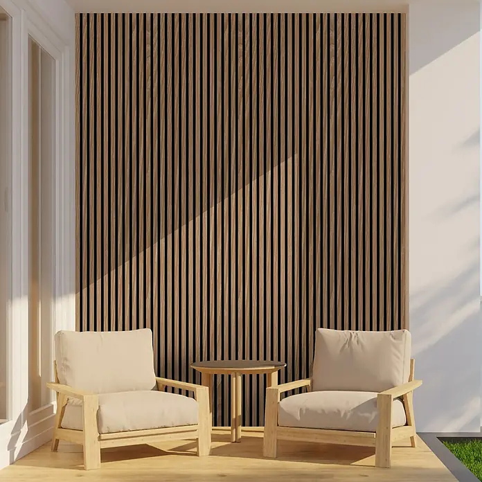 FN Neuhofer Akustikpaneel Aluminium Foliert - Eiche, L x B x S: 2.400 x 565 x 17 mm - Zwei Sessel und ein Tisch auf einer Terrasse vor einer Holzwand. Die helle Holzfarbe der Möbel ergänzt die dunkleren Holzlatten.