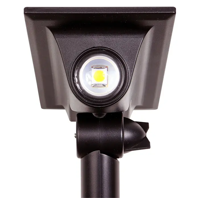 Arte confort Lámpara con pica Haloz - 2 W, Blanco cálido - Primer plano de una lámpara solar de jardín negra con un LED brillante. Ideal para iluminar espacios exteriores.