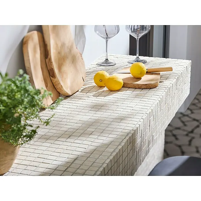 Mosaikfliese Quadrat Uni MOS TN23W - 30,5 x 30,5 cm, Cremeweiß, Matt - Nahaufnahme einer Kücheninsel mit Mosaikfliesen, dekoriert mit Zitronen, Holzbrett und Gläsern. Das helle Design verleiht der Küche eine frische Note.