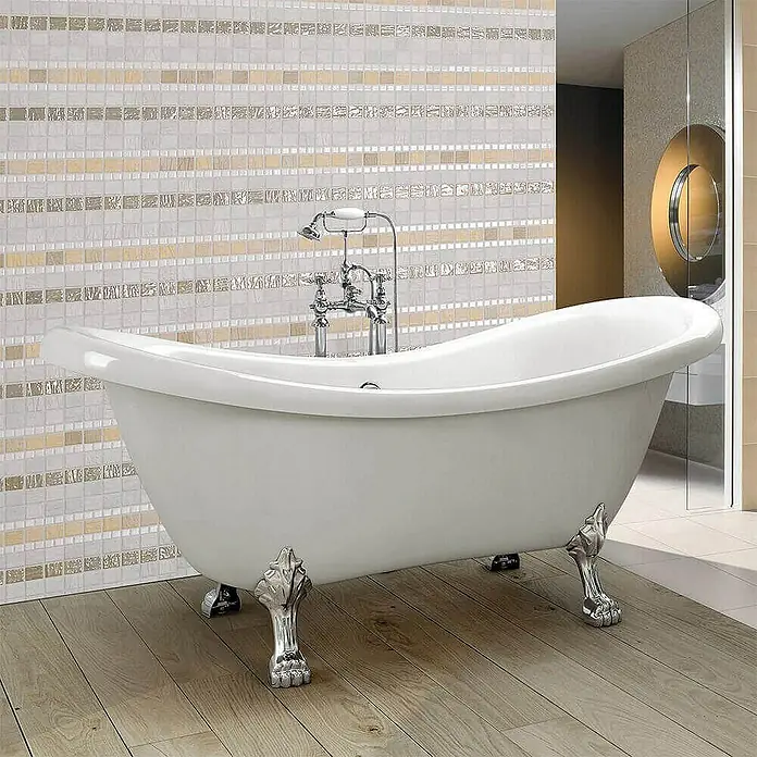 Home Deluxe Freistehende Badewanne FAMA - Weiß - Freistehende Badewanne mit dekorativen Füßen und Armaturen, vor einer Wand mit Mosaikfliesen.