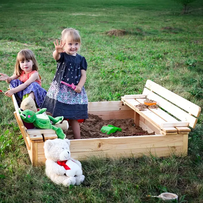 Timbela Sandkasten - L x B: 122 x 118 cm, Holz, Natur - Zwei spielende Kinder in einem Sandkasten mit Holzrahmen, mit Spielzeug und einem klappbaren Deckel.