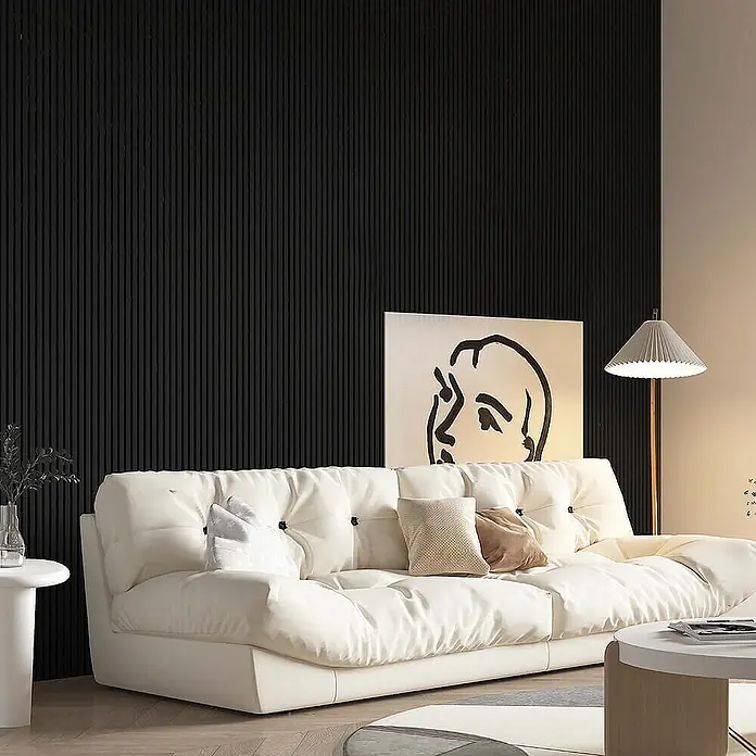 Home Deluxe Akustikpaneel SONIC - Deep Black 12er Set - Tief Schwarz, L x B x S: 2,2 cm x 40,5 cm x 22 mm, 12 Stk., 3,88 m² - Dieses Bild zeigt ein modernes Wohnzimmer mit einem cremefarbenen Sofa, einem Kunstwerk und einer Stehlampe. Die dunkle Wand bietet einen schönen Kontrast.