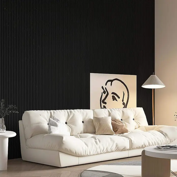 Home Deluxe Akustikpaneel SONIC Deep Black - H 240 x B 40 x T 2,1 cm - Tief Schwarz, L x B x S: 240 cm x 2,1 cm x 21 mm, 1 Stk., 0,97 m² - Ein gemütliches, cremefarbenes Sofa mit Knopfheftung und Zierkissen vor einer dunklen Akzentwand, ergänzt durch eine Stehlampe und ein abstraktes Kunstwerk.