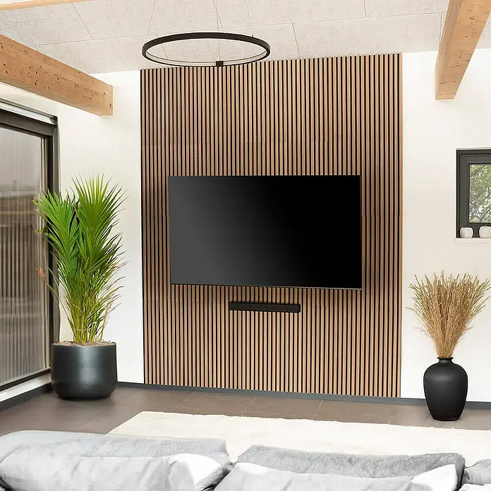 Home Deluxe Akustikpaneel SONIC - Oiled Oak 9er Set - Eiche, L x B x S: 2,2 cm x 40,5 cm x 22 mm, 9 Stk., 2,91 m² - Ein modernes Wohnzimmer mit einem großen Flachbildfernseher an einer Holzpaneelwand und einer kreisförmigen Deckenleuchte.