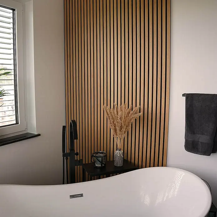 Home Deluxe Akustikpaneel SONIC - Oiled Oak 6er Set - Eiche, L x B x S: 2,2 cm x 40,5 cm x 22 mm, 6 Stk., 1,94 m² - Badezimmer-Interieur mit einer modernen, freistehenden Badewanne und einer stilvollen Holzpaneelwand als Blickfang, ergänzt durch dekorative Elemente.