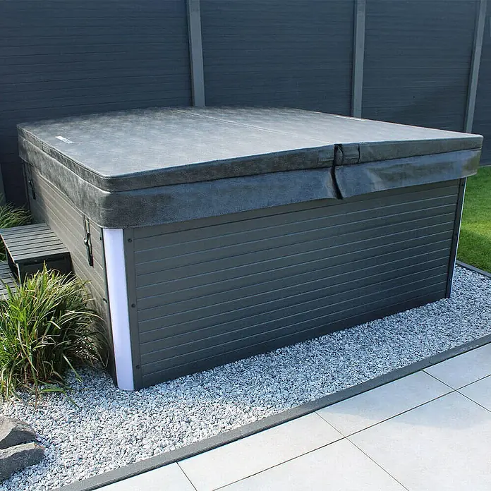 Home Deluxe Außen-Whirlpool STREAM BIG inkl. Treppe und Thermoabdeckung - 207,5 x 207,5 x 88 cm, Anthrazit, Max. Personenzahl: 5 Stk. - Abgedeckter Whirlpool im Außenbereich, umgeben von Kies. Die Abdeckung schützt den Pool und hält ihn sauber.