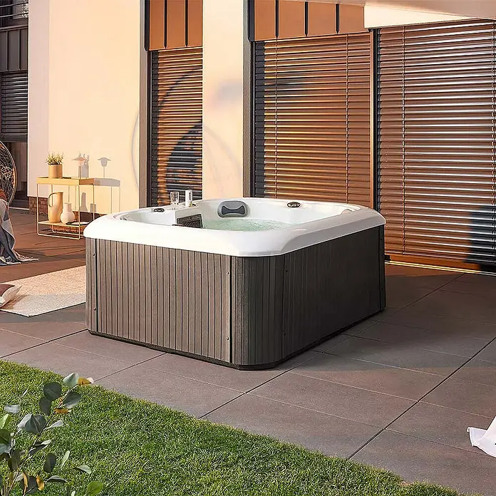 Home Deluxe Outdoor Whirlpool SEA STAR Pure -  - Elegantes Außenambiente mit einem modernen Whirlpool. Der Pool verfügt über eine graue Verkleidung und eine weiße Innenseite und lädt zum Entspannen ein.