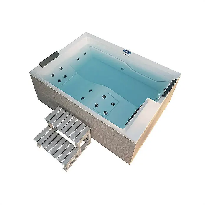 Home Deluxe Außen-Whirlpool NIMBUS DELUXE inkl. Treppe und Thermoabdeckung - Weiß, Max. Personenzahl: 2 Stk. - Bild eines Whirlpools mit integrierten Stufen. Der Whirlpool ist mit Wasser gefüllt und verfügt über Düsen für ein entspannendes Badeerlebnis.