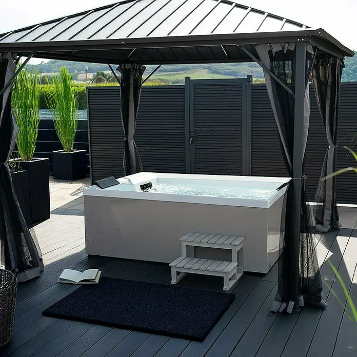 Home Deluxe Außen-Whirlpool NIMBUS DELUXE inkl. Treppe und Thermoabdeckung - Weiß, Max. Personenzahl: 2 Stk. - Bild eines modernen Whirlpools unter einem Pavillon mit Vorhängen, Treppe und Buch.