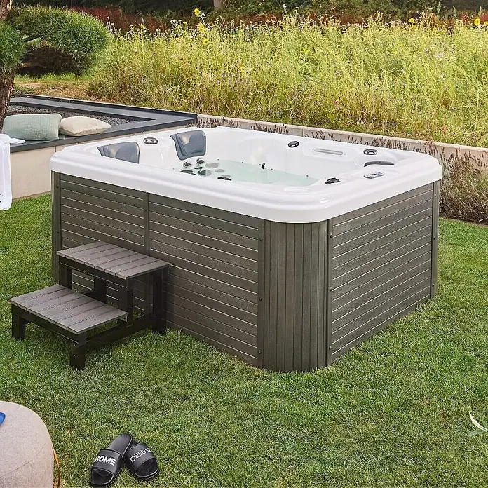 Home Deluxe Outdoor Whirlpool BEACH Mit Treppe und Thermoabdeckung -  - Ein luxuriöser Whirlpool mit Treppe in einem gepflegten Garten, ideal für Entspannung im Freien.