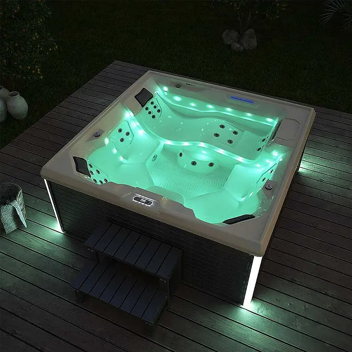 Home Deluxe Außen-Whirlpool STREAM BIG PURE - Anthrazit, Max. Personenzahl: 5 Stk. - Ein luxuriöser Whirlpool mit grüner Beleuchtung auf einer Holzterrasse, ideal für entspannende Stunden im Freien.