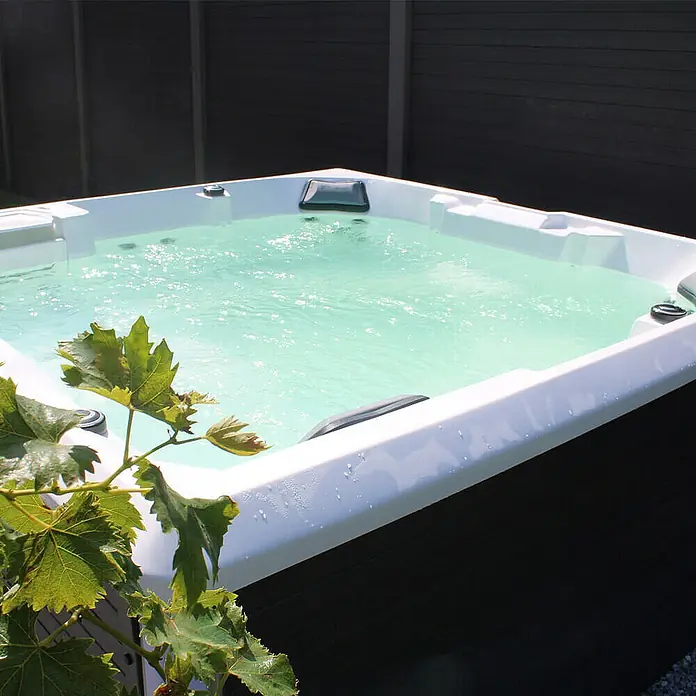 Home Deluxe Außen-Whirlpool STREAM BIG PURE - Anthrazit, Max. Personenzahl: 5 Stk. - Nahaufnahme eines luxuriösen Whirlpools mit kristallklarem Wasser und moderner Ausstattung, ideal für Entspannung im Freien.