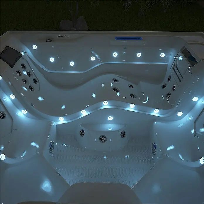 Home Deluxe Außen-Whirlpool STREAM BIG PURE - Anthrazit, Max. Personenzahl: 5 Stk. - Ein detailreiches Bild eines Whirlpools, der mit zahlreichen Lichtern beleuchtet ist, die die Formen und Düsen hervorheben.