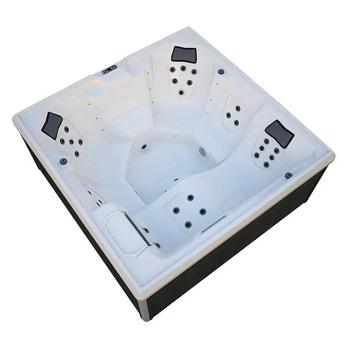 Home Deluxe Außen-Whirlpool STREAM BIG PURE - Anthrazit, Max. Personenzahl: 5 Stk. - Hochwinkelaufnahme eines leeren quadratischen Whirlpools mit mehreren Sitzen und Düsen in einem weißen Innenraum.