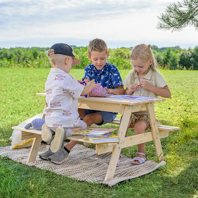 Timbela Kinder-Sitzgruppen-Set - 90 x 90 x 50 cm, Holz, Mit Staufach - Kinder sitzen an einem hellen Holz-Picknicktisch im Freien und malen. Ideal für den Garten.