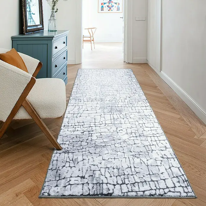 Teppichläufer Aqua - Grau, 350 x 80 cm, 100 % Polyamid - Ein moderner Läufer mit abstraktem Muster liegt auf einem Holzboden und verleiht dem Raum eine stilvolle Note.