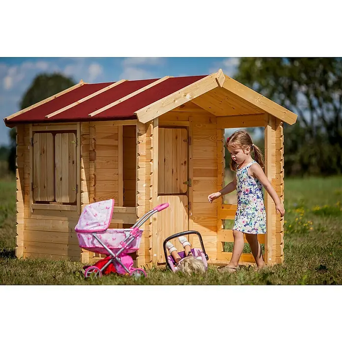 Timbela Spielhaus M501 - L x B x H: 182 x 146 x 145 cm, Holz, Natur - Eine junge Dame spielt vor einem Blockhaus mit rotem Dach, daneben ein Kinderwagen und eine Puppe.