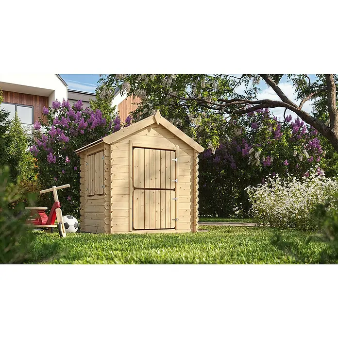 Timbela Spielhaus - L x B x H: 112 x 146 x 143 cm, Holz, Natur - Nahaufnahme eines Holzspielhauses im Garten mit einem kleinen Fenster und einer zweigeteilten Tür, umgeben von üppigem Grün.