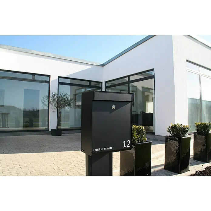 Allux Briefkasten Grundform - L x B x H: 180 x 345 x 440 mm, Schwarz, Stahl - Moderne schwarze Briefkastenanlage mit Hausnummer und Namensschild vor einem modernen Wohnhaus.