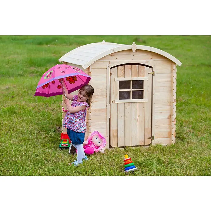 Timbela Spielhaus M505 - L x B x H: 112 x 146 x 145 cm, Holz, Natur - Ein Kind steht mit einem Regenschirm vor einem hellen Holzspielhaus im Garten, umgeben von Spielsachen.