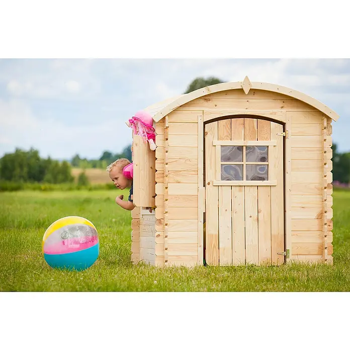 Timbela Spielhaus M505 - L x B x H: 112 x 146 x 145 cm, Holz, Natur - Ein Junge spielt in einem Holzspielhaus im Freien mit einem bunten Ball. Das Spielhaus verfügt über eine Tür und ein Fenster.
