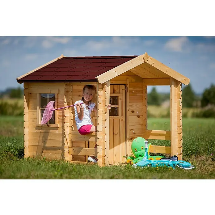 Timbela Spielhaus M501A - L x B x H: 182 x 146 x 145 cm, Holz, Natur - Ein Mädchen sitzt in einem hölzernen Spielhaus mit rotem Dach, umgeben von Spielzeug und einer grünen Wiese.