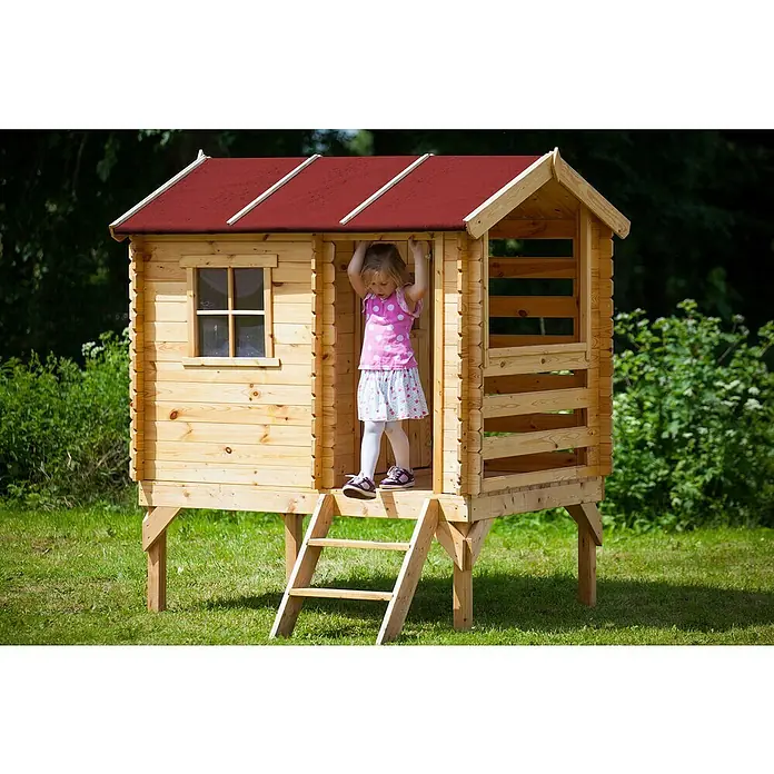 Timbela Spielhaus - L x B x H: 182 x 146 x 205 cm, Holz, Natur - Ein hölzernes Spielhaus mit rotem Dach auf einem Rasen, ein Kind steht in der Tür und hält sich fest. Das Spielhaus ist auf Stelzen gebaut.