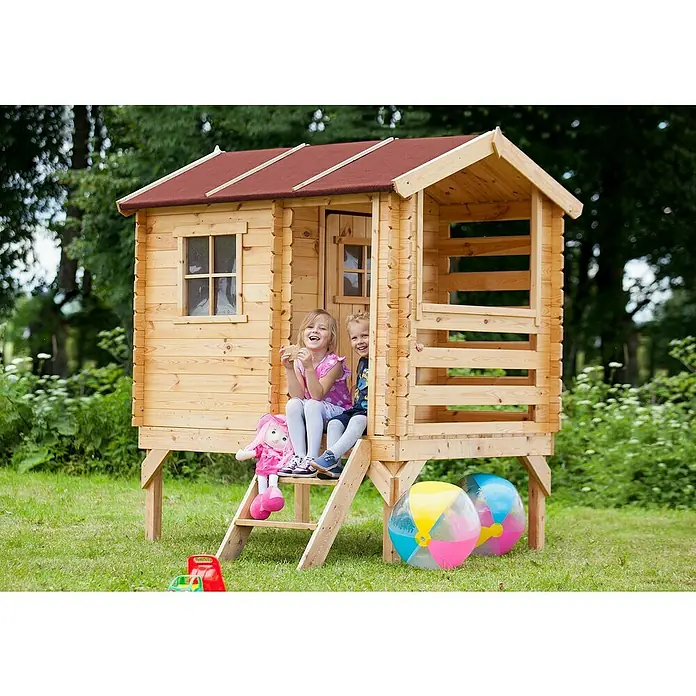 Timbela Spielhaus - L x B x H: 182 x 146 x 205 cm, Holz, Natur - Ein Holzspielhaus für Kinder mit rotem Dach und zwei Kindern auf der Treppe. Spielzeug liegt im Gras.