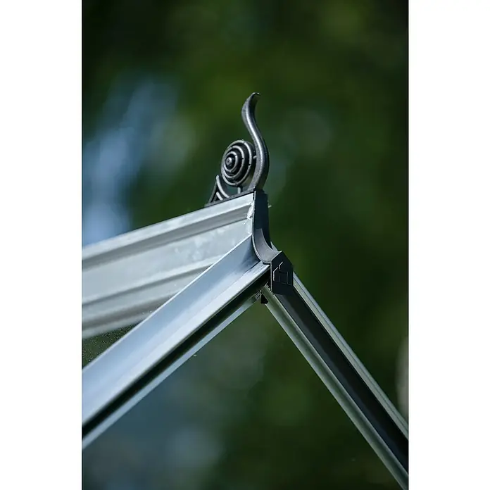Halls Gewächshaus Icon 6 Einscheiben-Sicherheitsglas - Außenmaß inkl. Dachüberstand (B x T): 192,5 x 316,9 cm, Material Seitenwand: Glas, 3 mm, Aluminium - Nahaufnahme des dekorativen Dachdetails eines Gewächshauses mit kunstvoller Verzierung auf grünem Hintergrund.