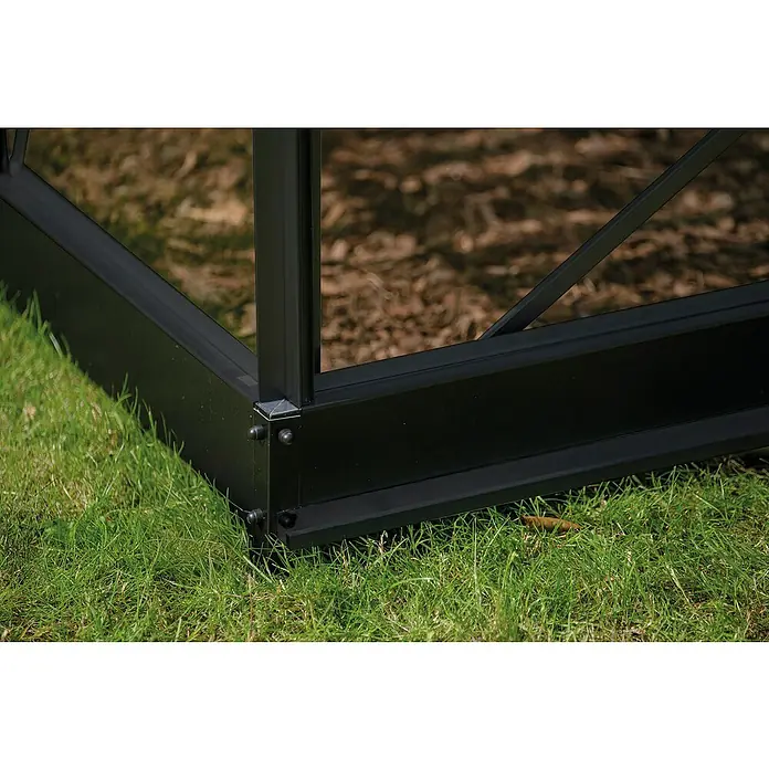 Halls Gewächshaus Icon Planthouse - Außenmaß inkl. Dachüberstand (B x T): 379,1 x 254,7 cm, Material Seitenwand: Glas, 3 mm, Schwarz - Detailansicht der schwarzen Aluminiumbasis eines Gewächshauses auf grünem Rasen. Robuste Konstruktion für den Außenbereich.